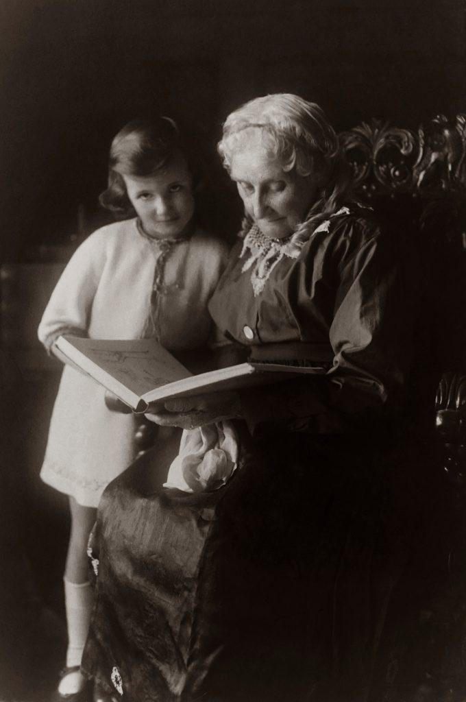 Petite fille avec sa grand-mère lisant un livre