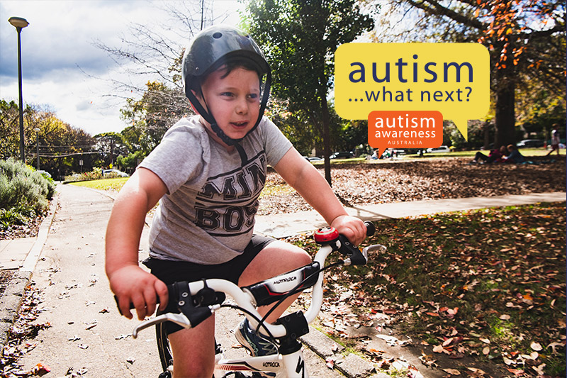 Boy with autism riding bike with Autism What Next logo
