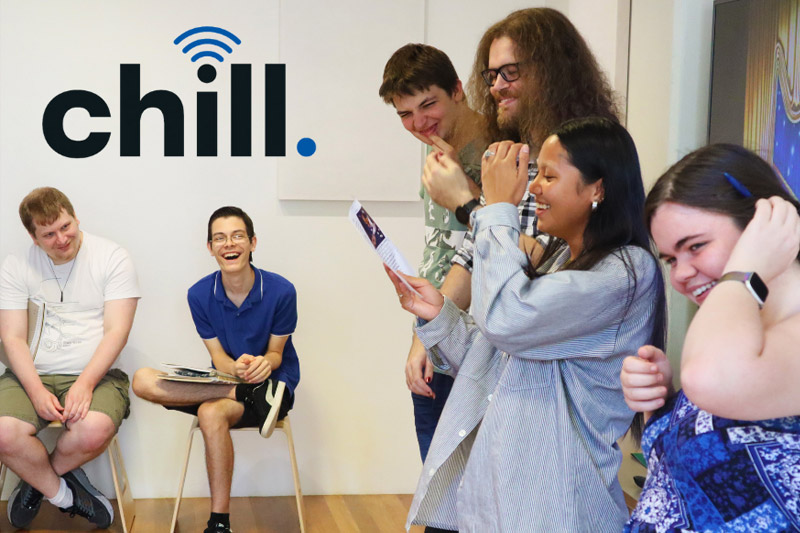 Group of Chill participants laughing together in a room with the chill logo on the wall behind