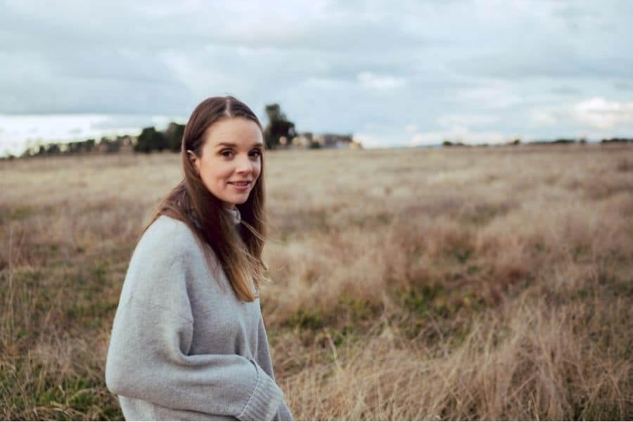 Young woman in country field looking at camera