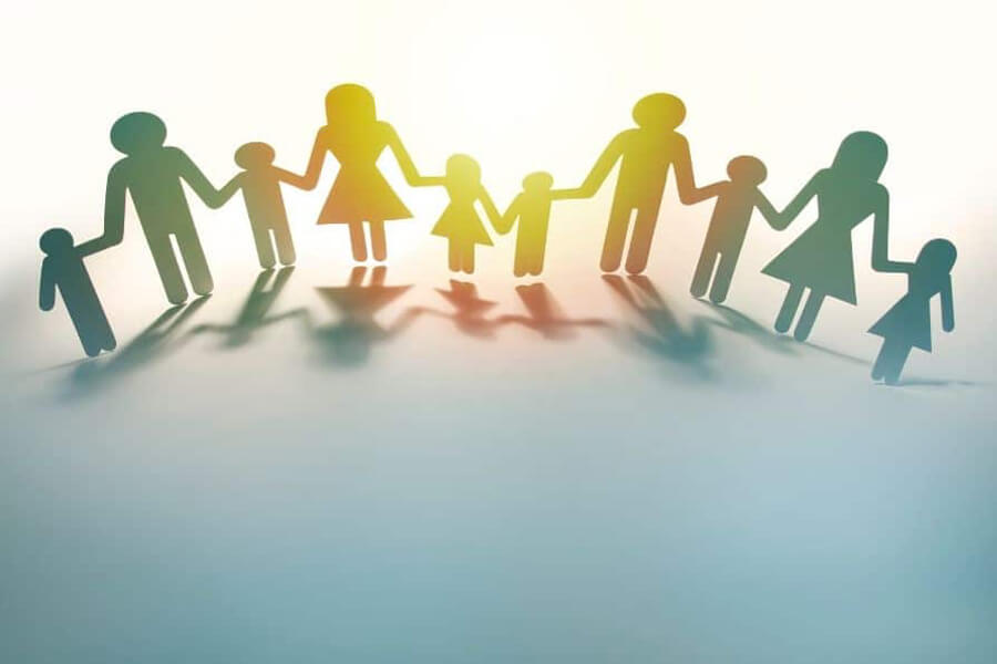 Concept image of a group of parents holding hands with children cut out of cardboard