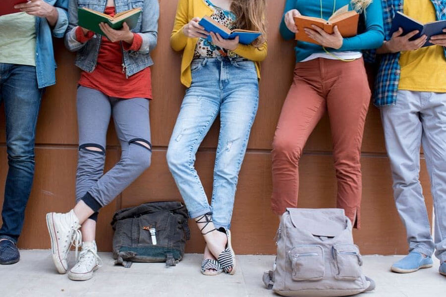 Group of young adults from waist down reading books