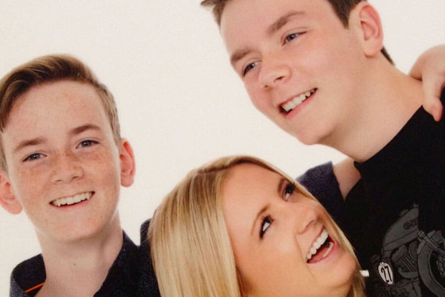 Three teenagers laughing and smiling together