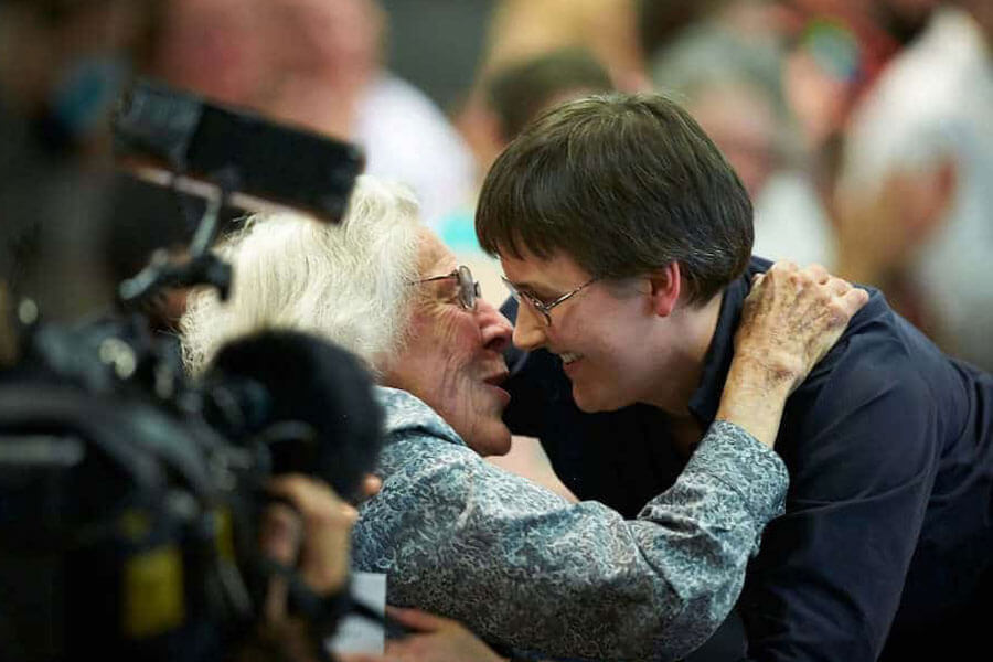 Young woman hugging elderly woman