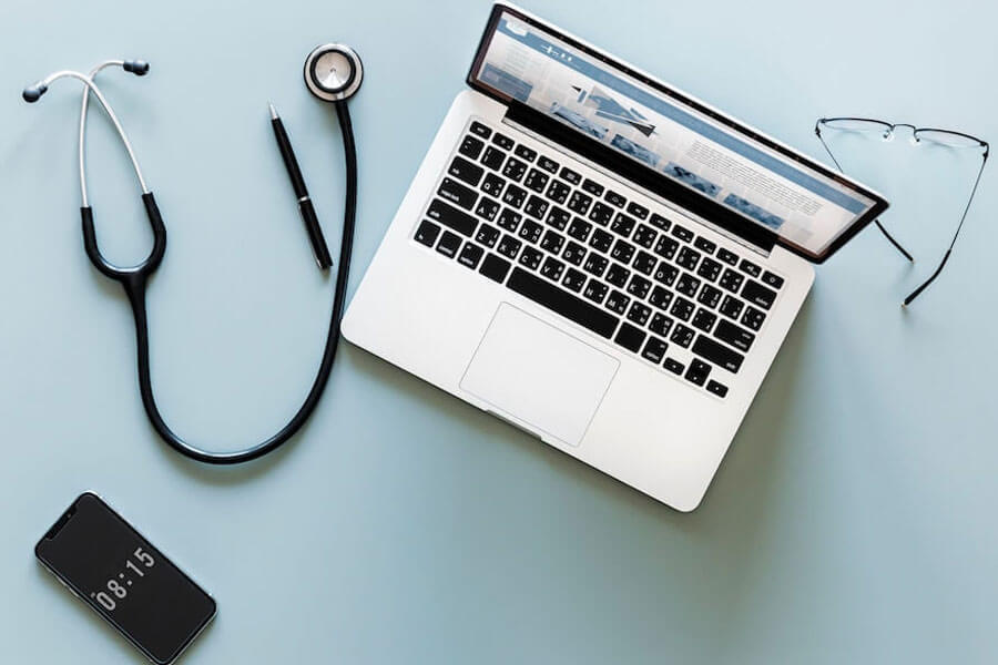 Concept image of laptop and stethoscope shot from above
