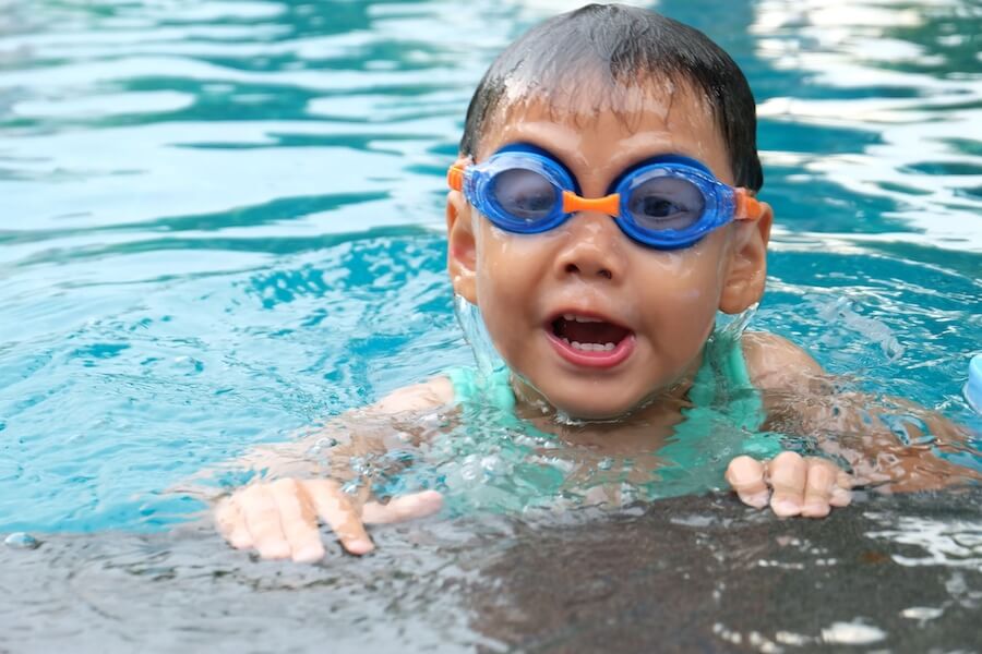Small child in pool with goggles