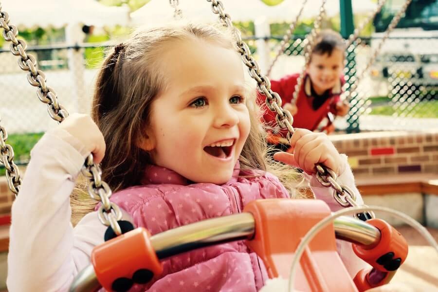 Small girl laughing on a swing