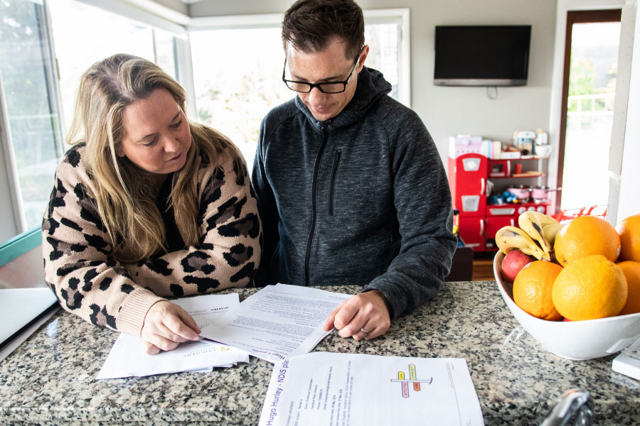 mum and dad at kitchen bench looking through paperwork