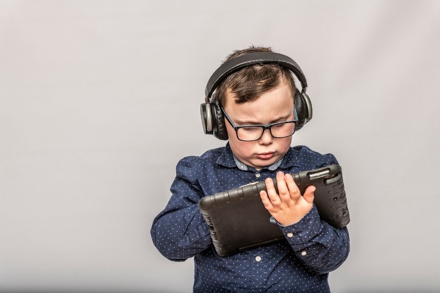 Young autistic boy wearing headphones using an ipad