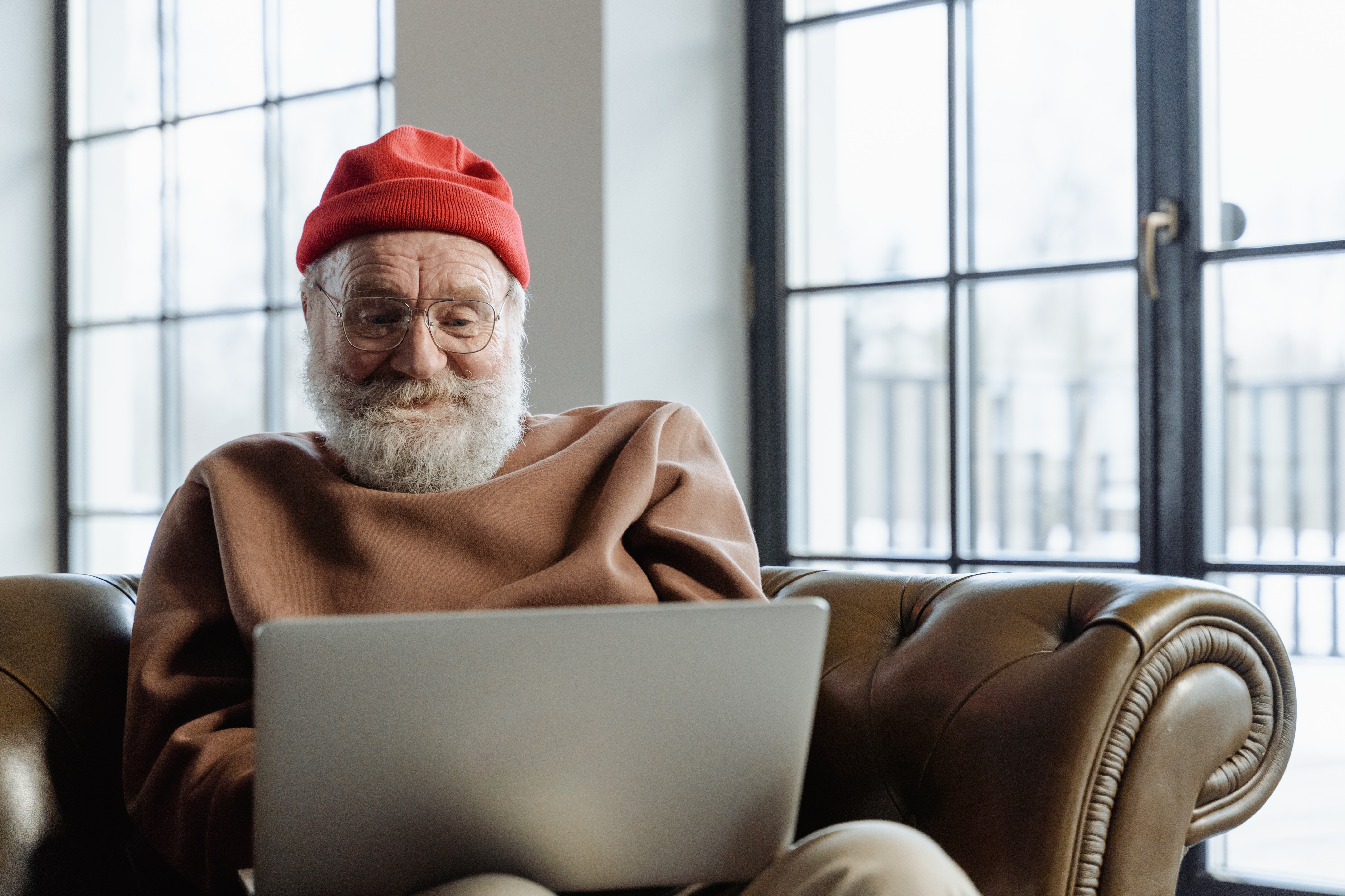 Senior in red hat using a laptop
