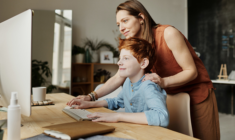 Woman helps her son use a computer