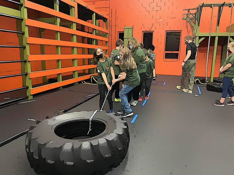 child on a thin board between tires exercise