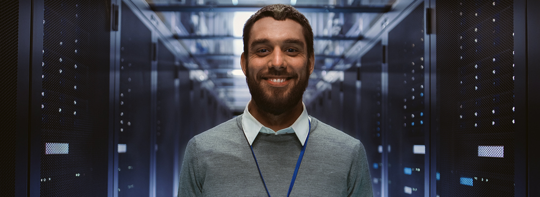 Homme souriant debout dans une salle de serveurs