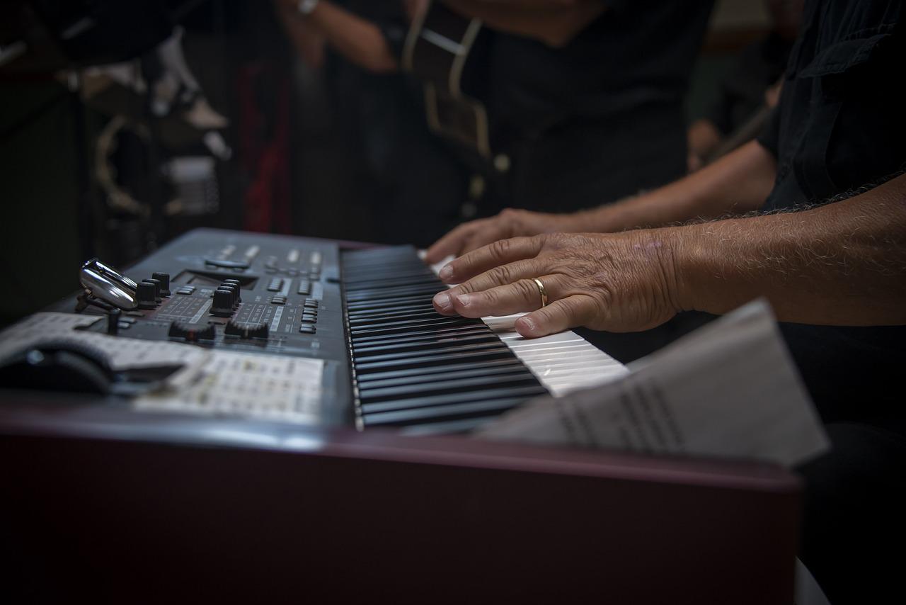 photo de mains jouant sur un piano durant un concert