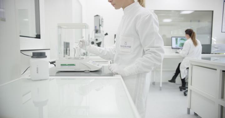 Two women in white coats working in a lab