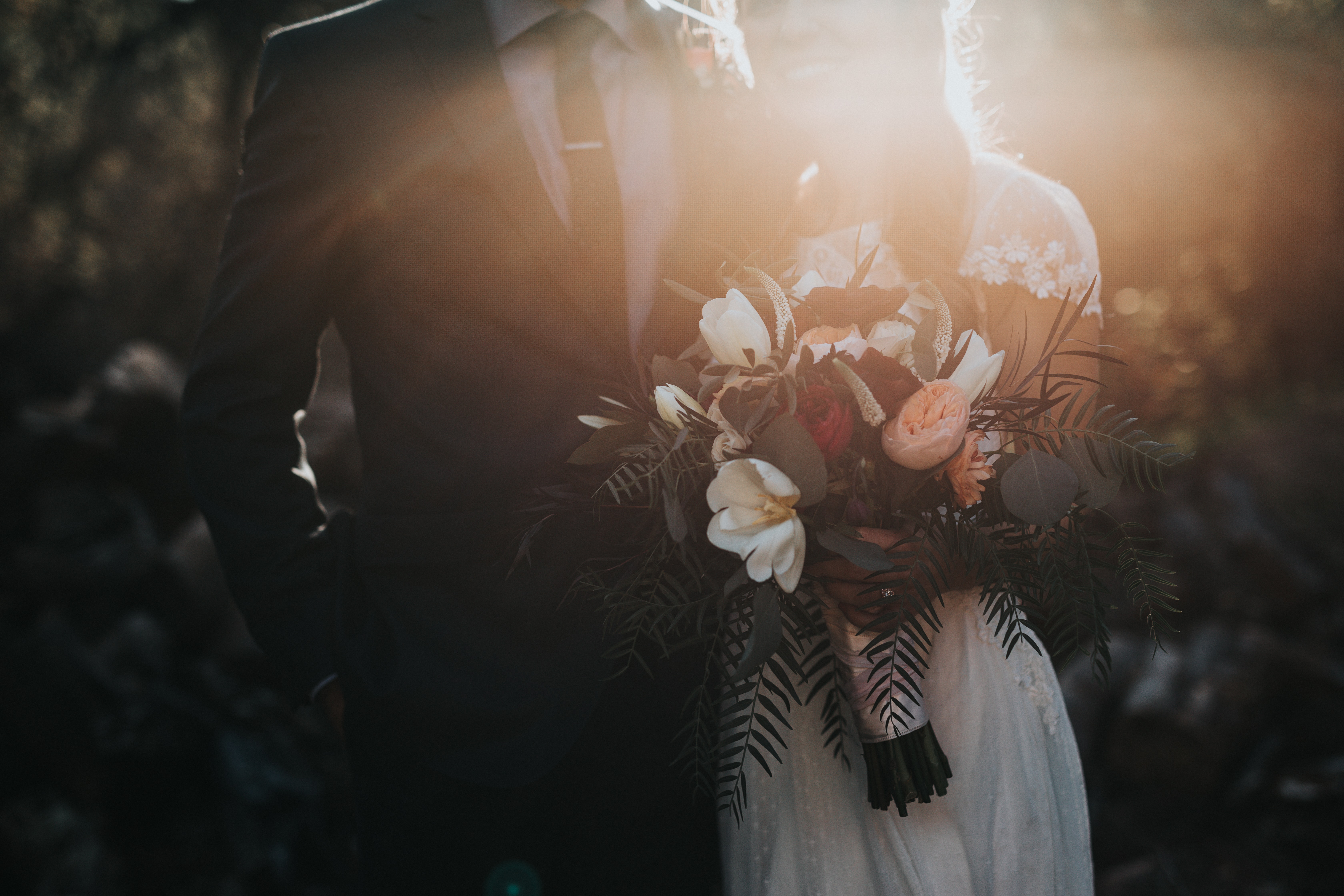 A couple poses in front of the sun