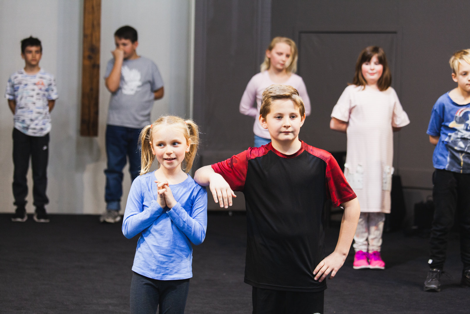 A picture of two children front and center during a recital during Drama Class.