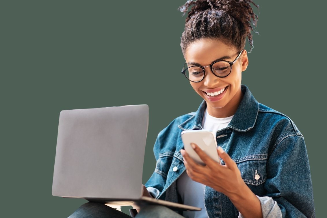 Woman in office environment using smartphone at desk.