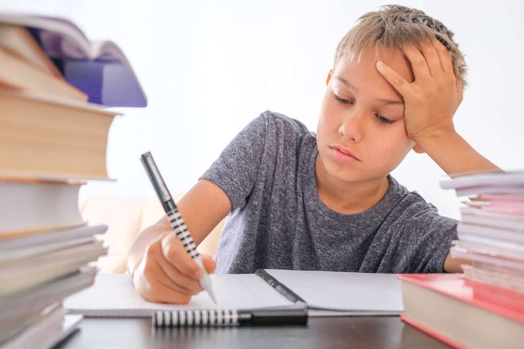 un bambino scrive su un quaderno