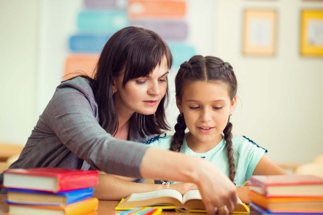 una maestra aiuta una bambina