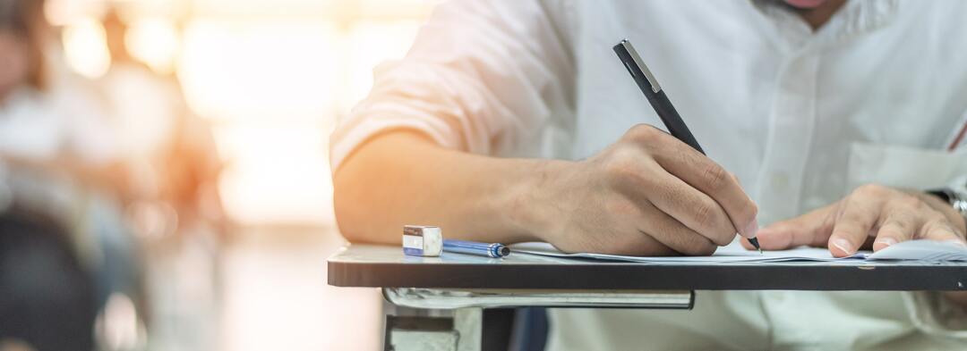 ragazzo scrive su un foglio durante un esame