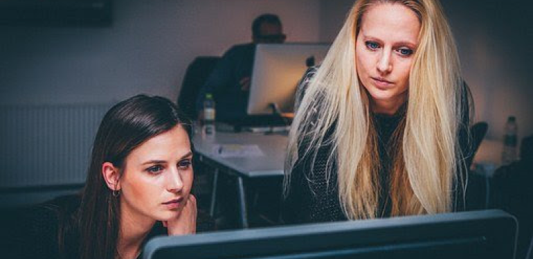 Two women looking at a computer.