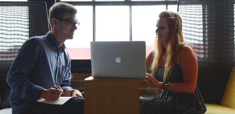 A man and a woman looking at a laptop.
