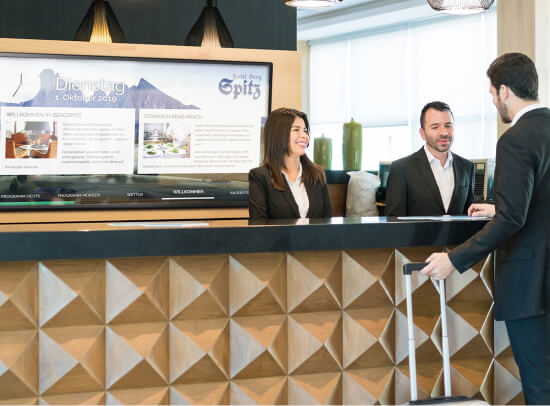 Gast der an einer Hotelrezeption ankommt