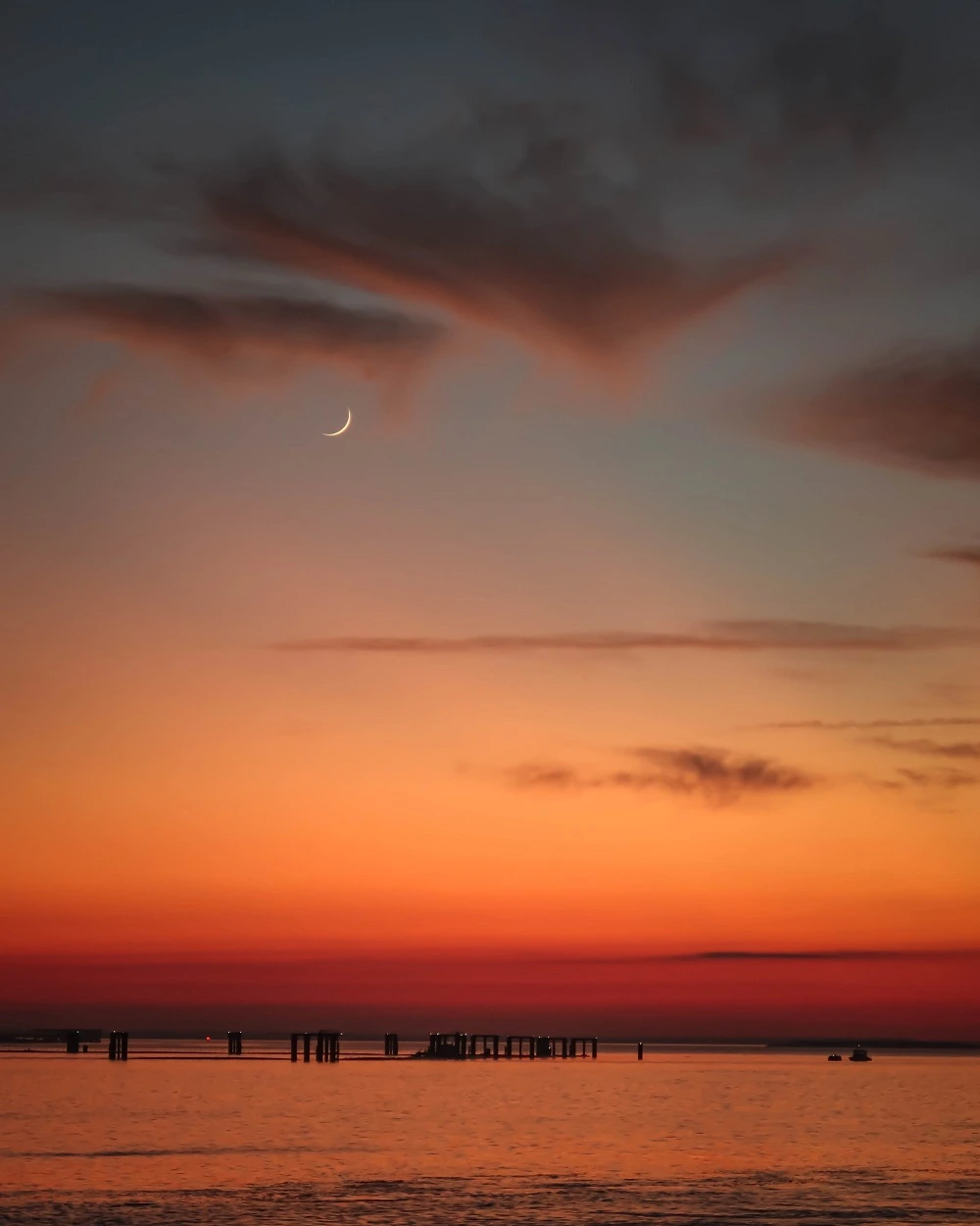 Golden Isles: sunset over the Atlantic Ocean with a sliver of the moon showing high above