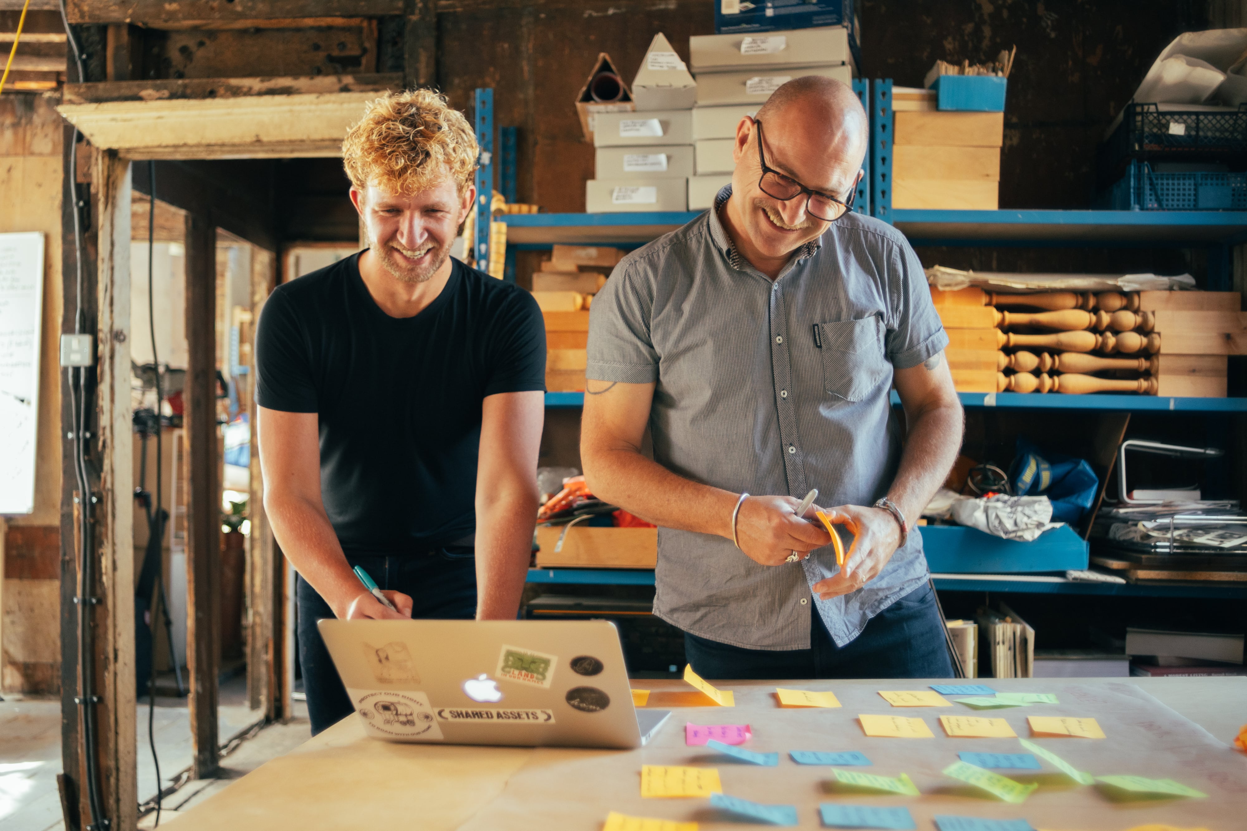 Tom, our Consultancy Coordinator and Mark, our Co-Director brainstorm over a laptop and post-it notes.