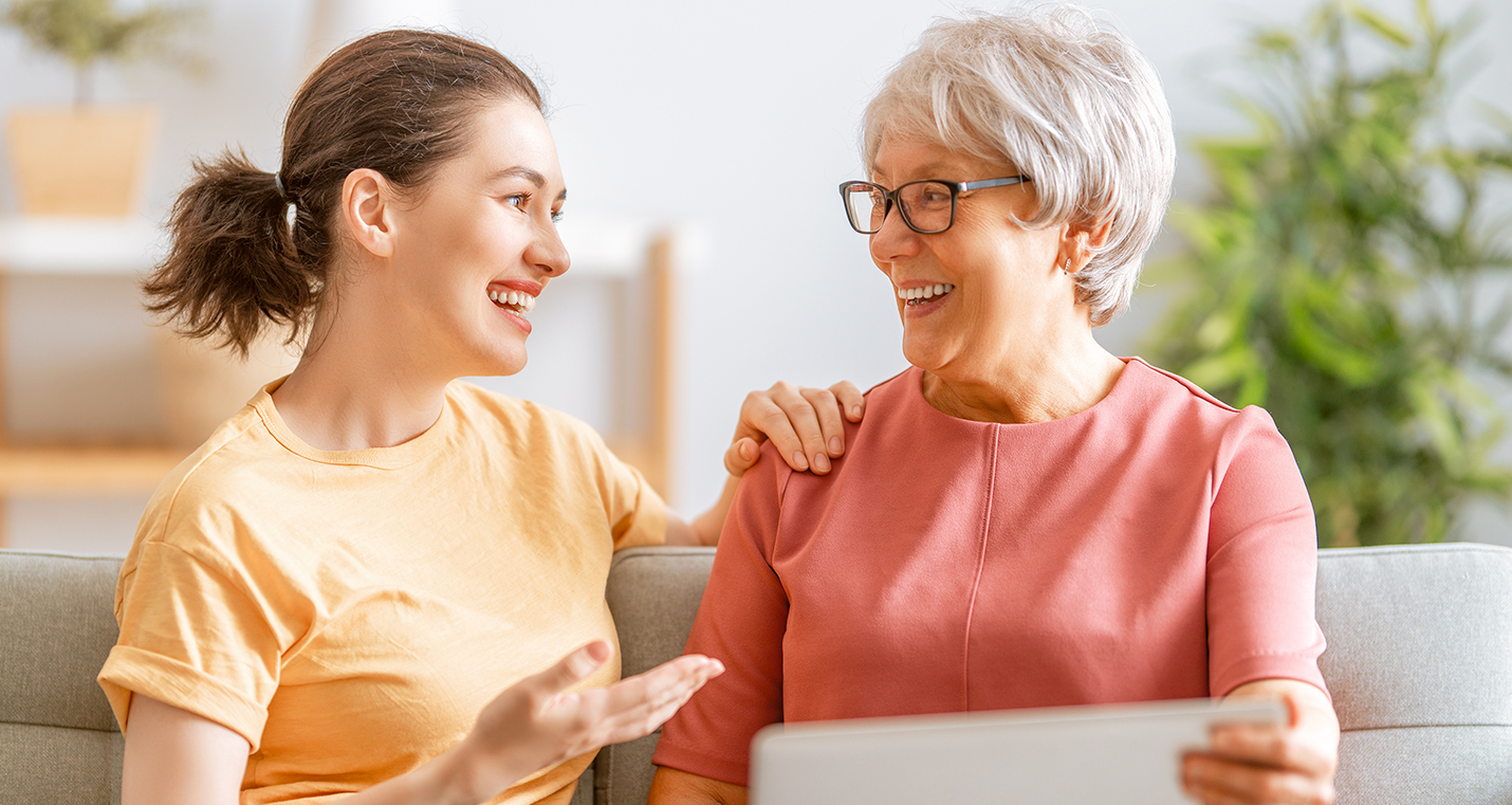 Mother and daughter laughing on couch.