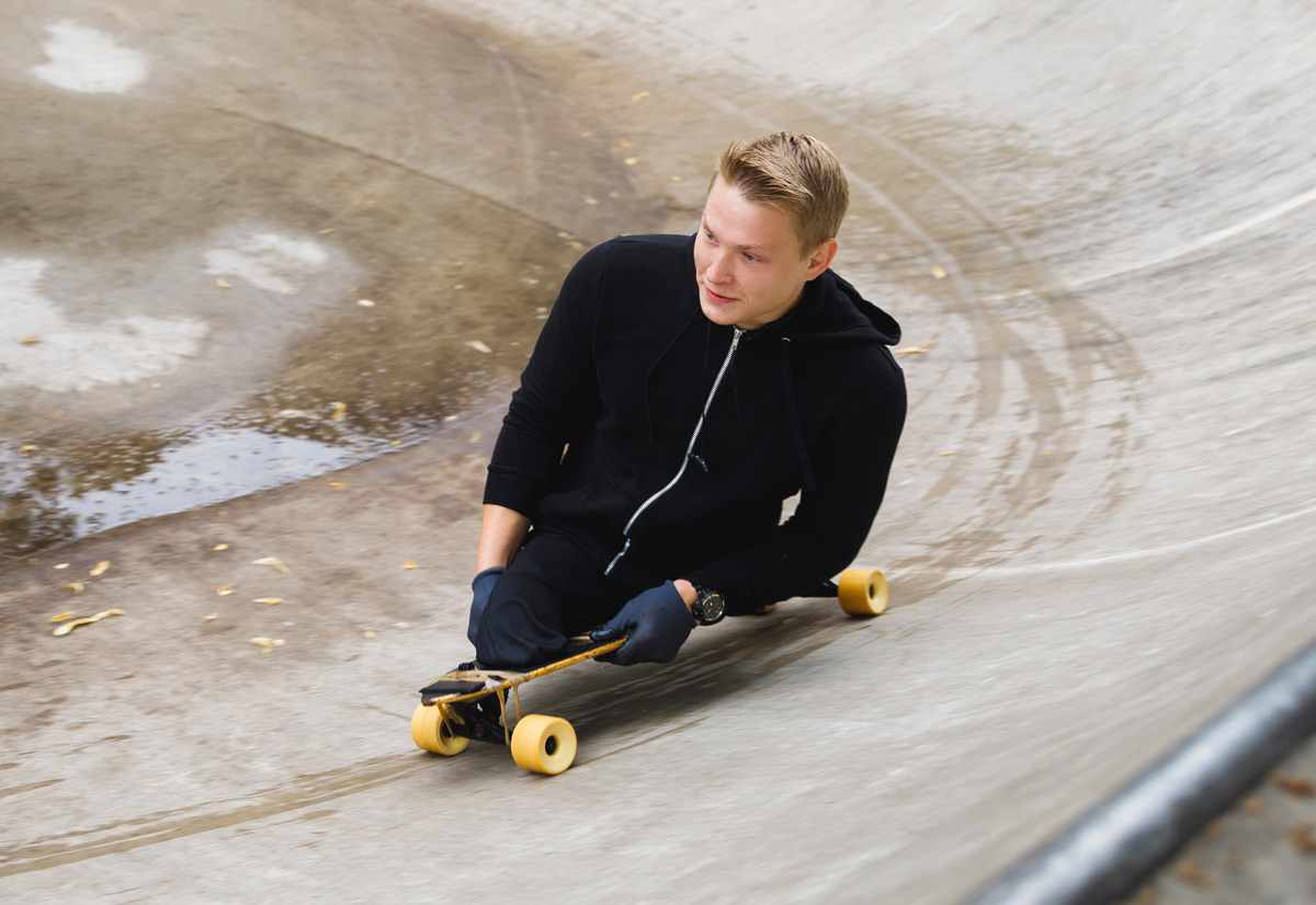 Ung man utan ben åker skateboard