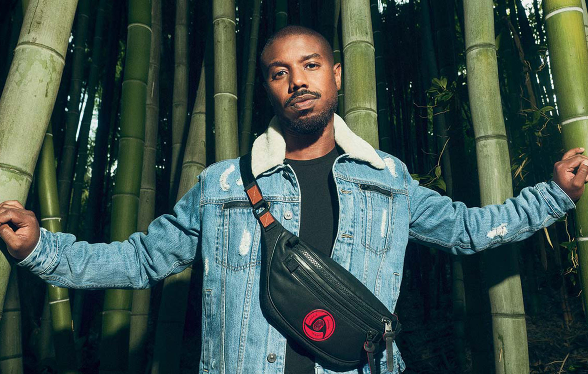 photo of male model wearing denim jacket with bamboo trees in background