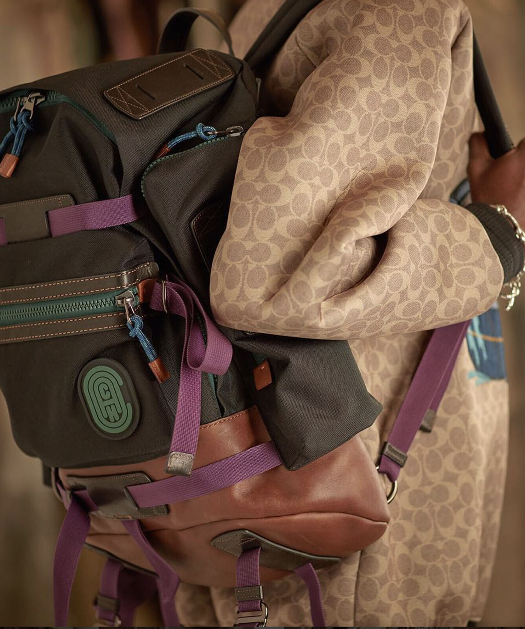 a photo of a brown backpack with a coach logo