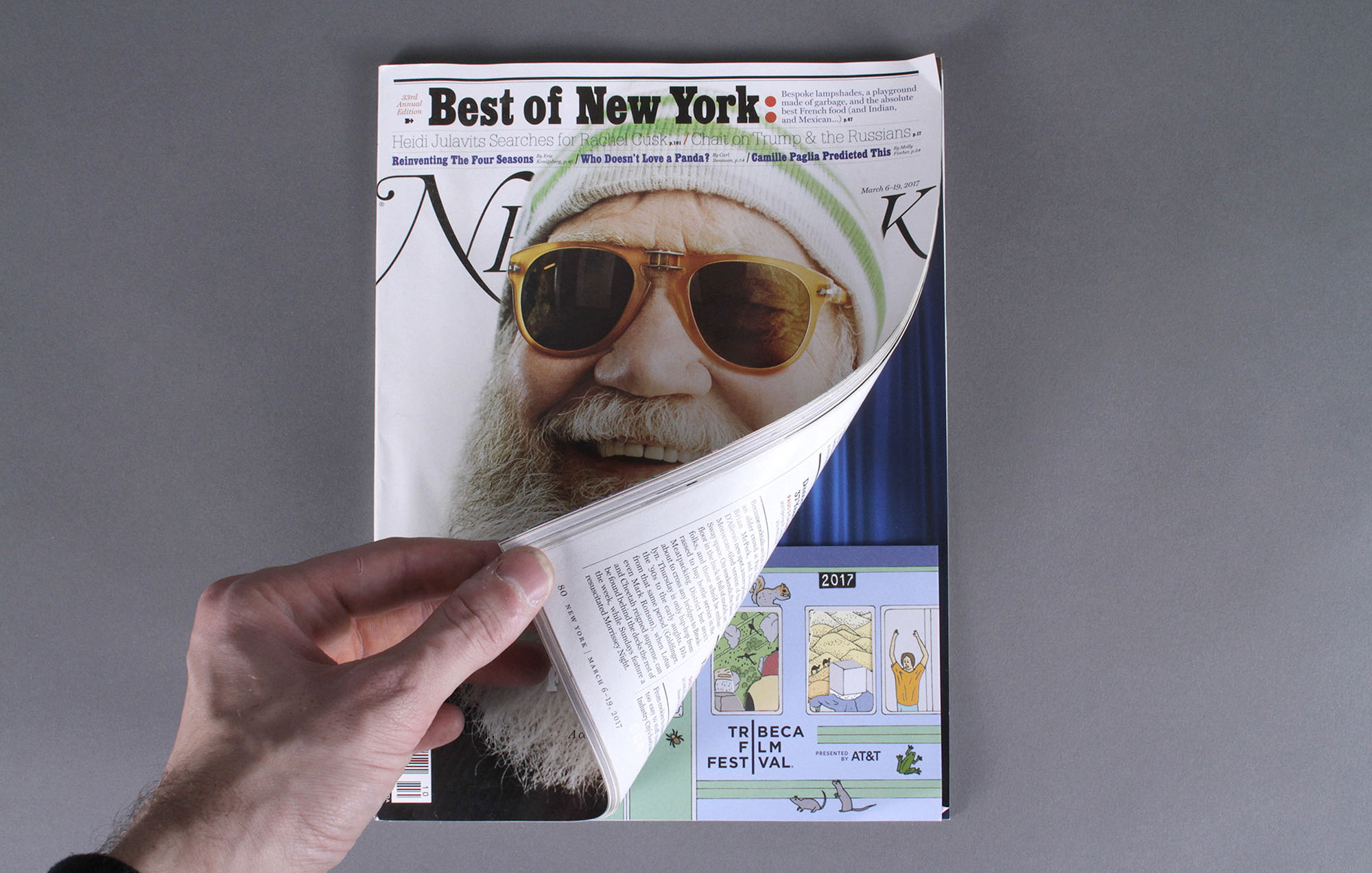 a photo of a magazine with a hand opening up the magazine slightly