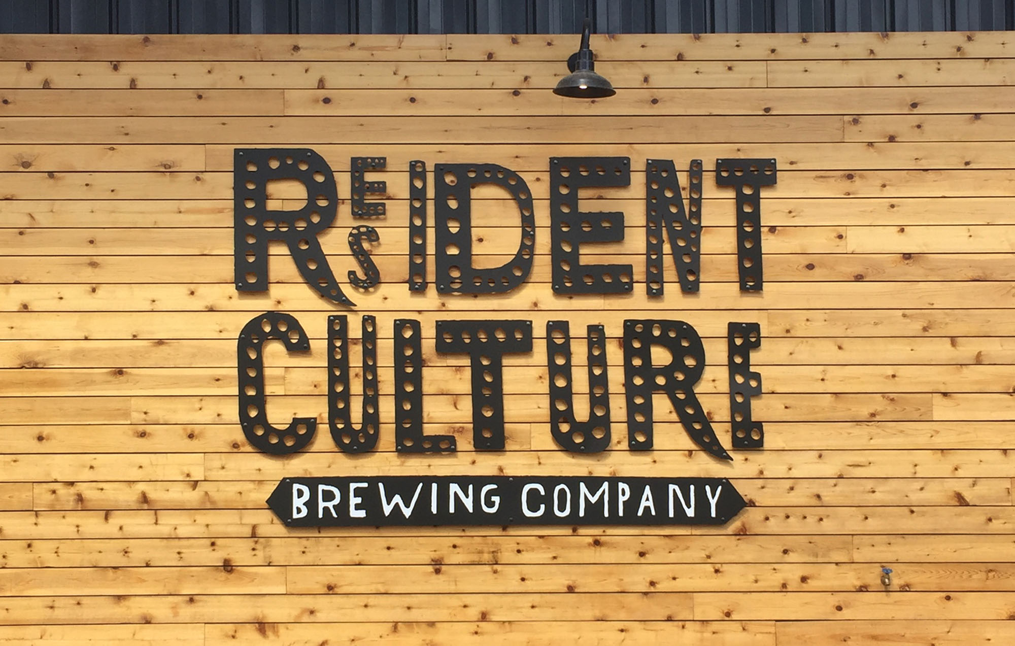 a photo of the resident culture logo on a wood panel