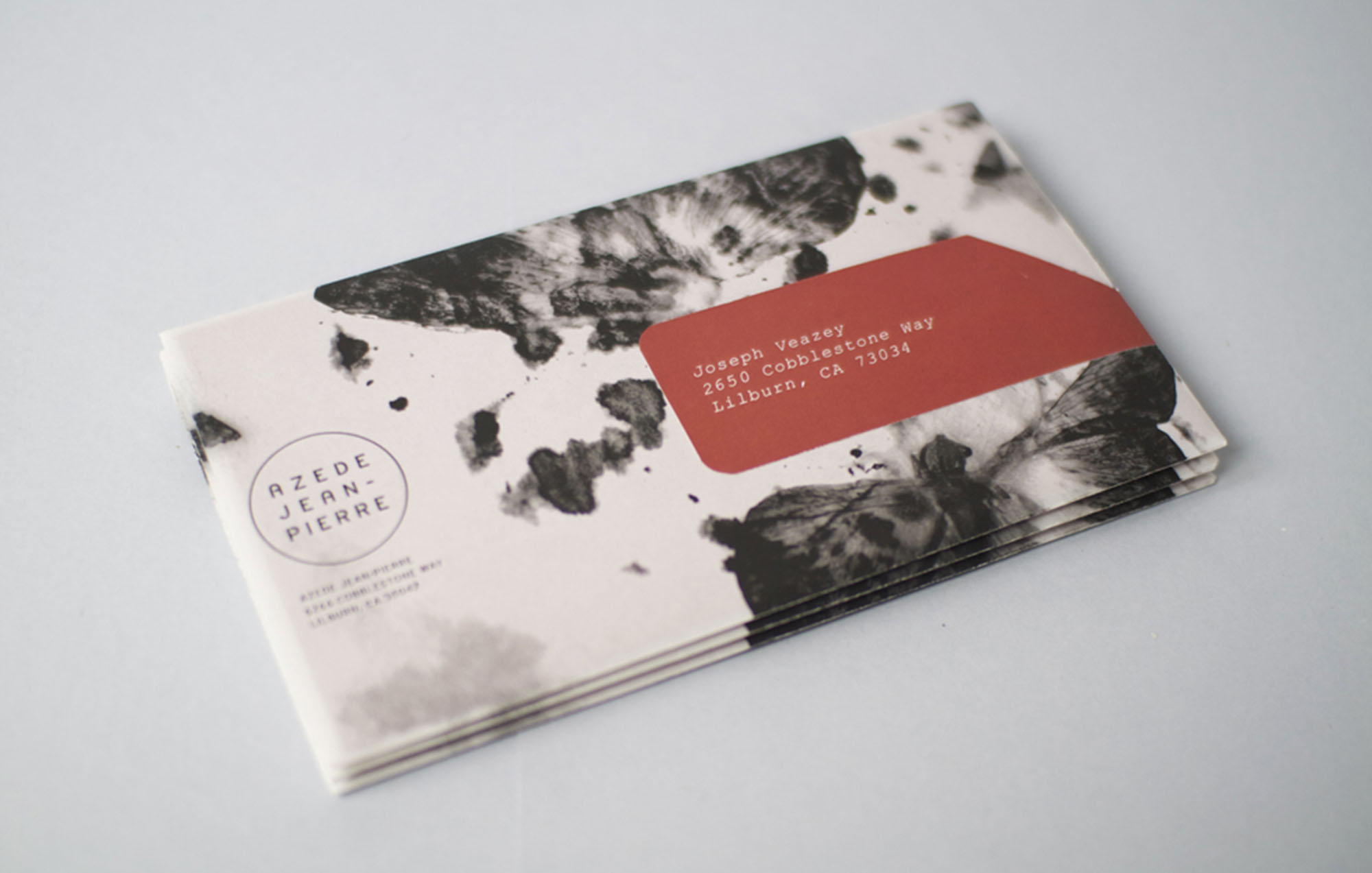 a photo of an envelope with the azede logo with black and white abstract art