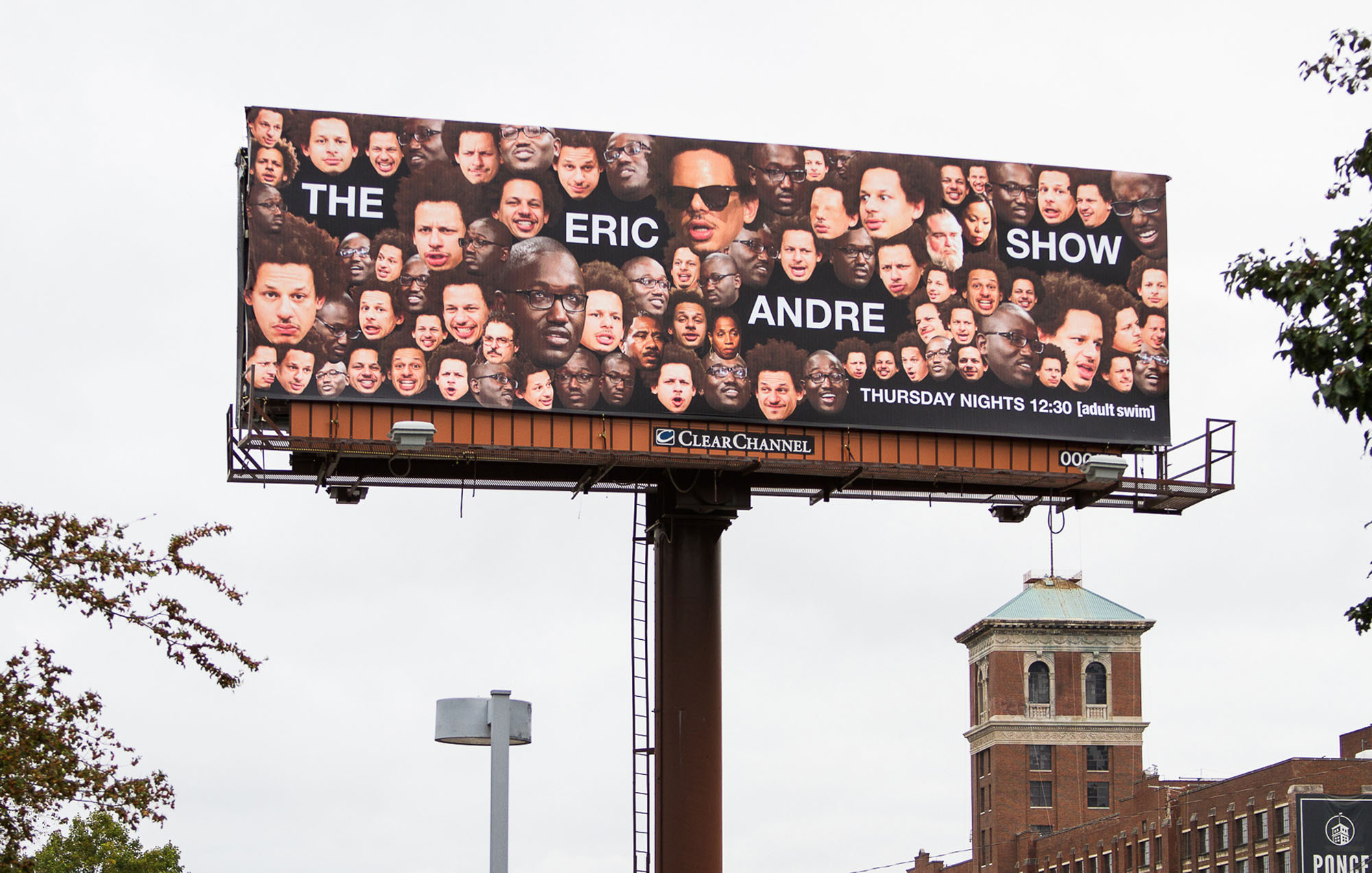 a billboard with a text that say the eric andre show with face cut outs surrounding the text