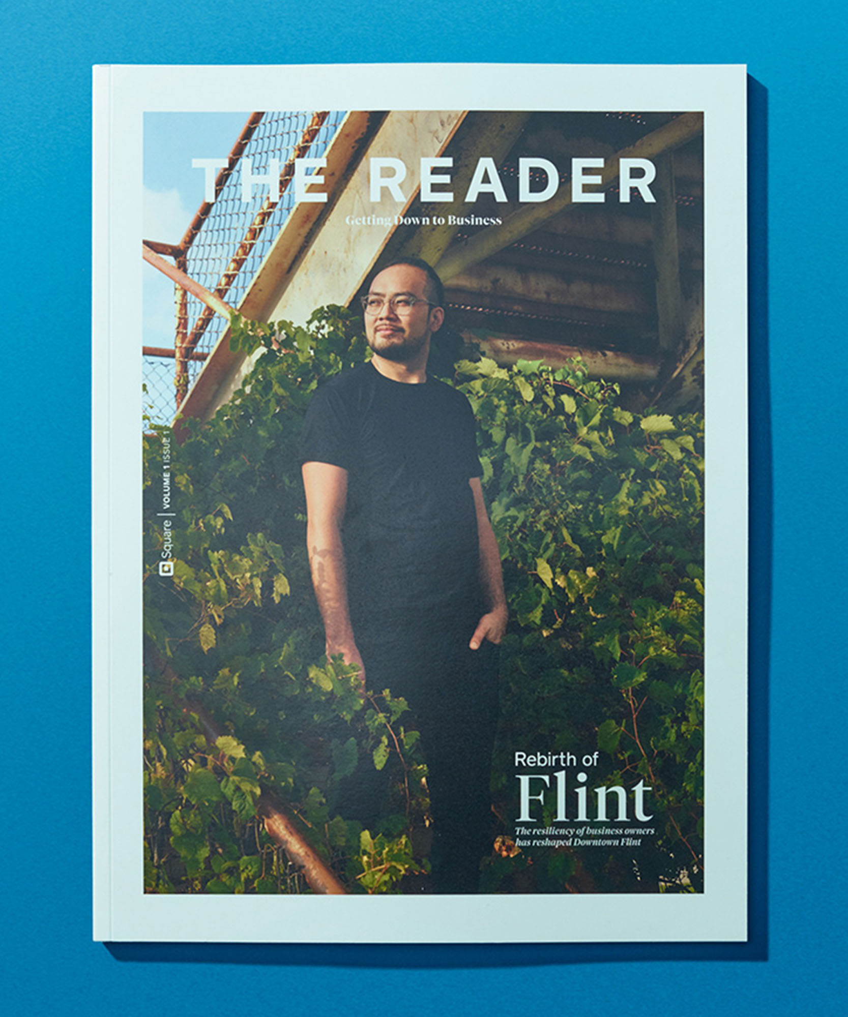 a photo of a magazine cover with the reader at the header and a man wearing all black on the stairs with green plants covering the stair rail
