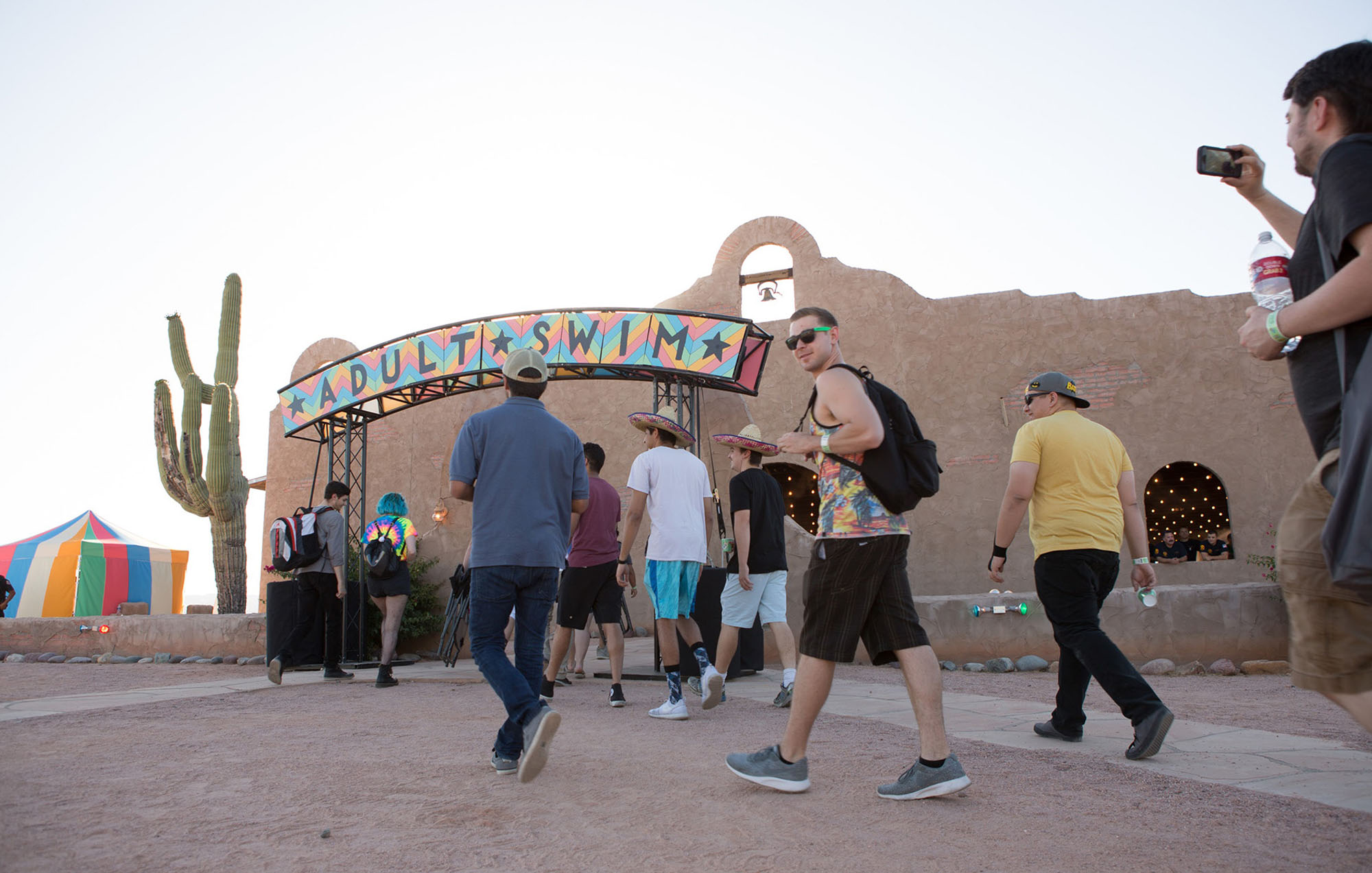 photo of people walking inside a sign that says adult swim