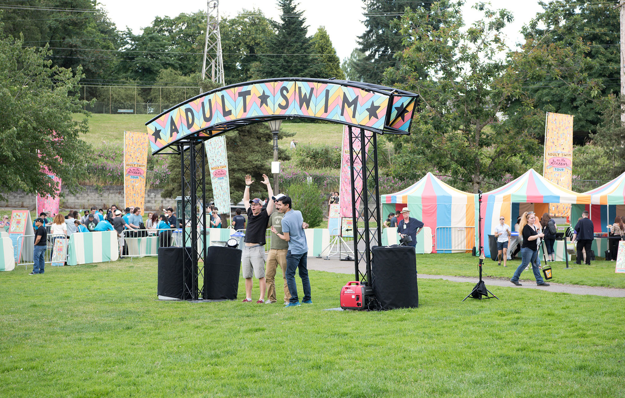 people on green grass looking excited under the adult swim sign