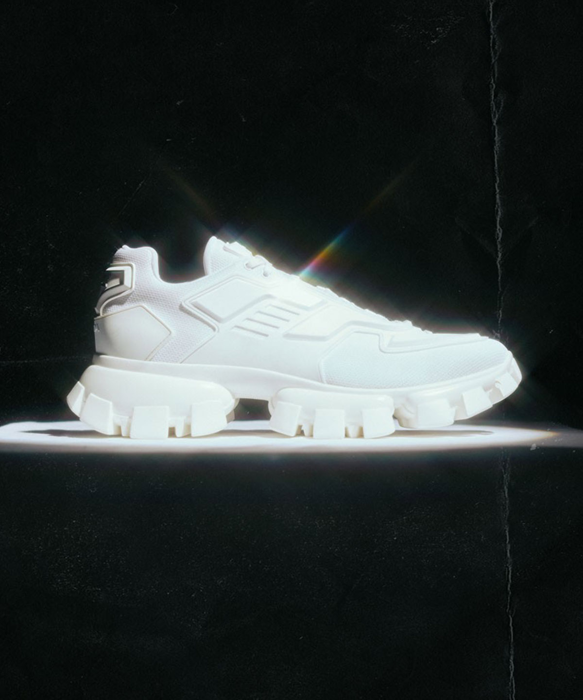 all black background with a white shoe with a light sparkle