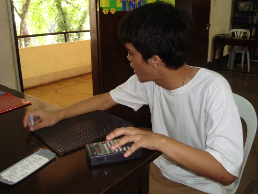 Cebu Braille Center Inc. - A visual impaired person using a calculator.
