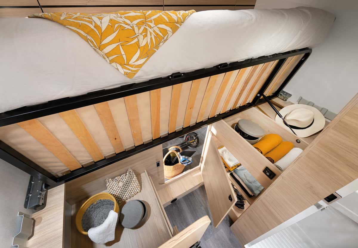 Hochgeklapptes Bett im Wohnmobil mit viel Stauraum darunter