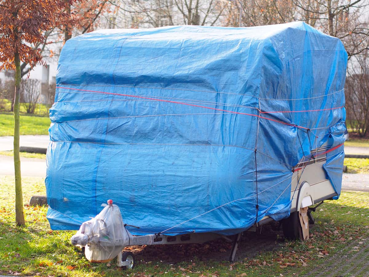 Ein Wohnmobil eingepackt in einer blauen Abdeckplane