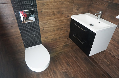 Piękna łazienka z nowoczesnymi płytkami, miską wc i umywalką nablatową