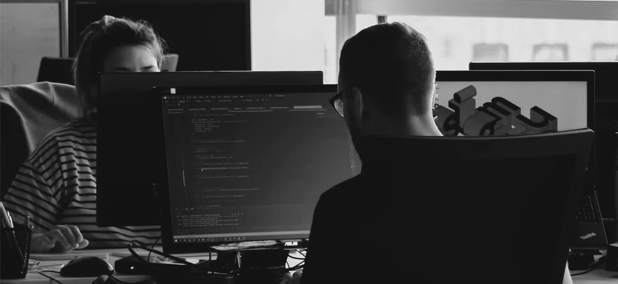 Mensen die achter de computer aan het werk zijn.