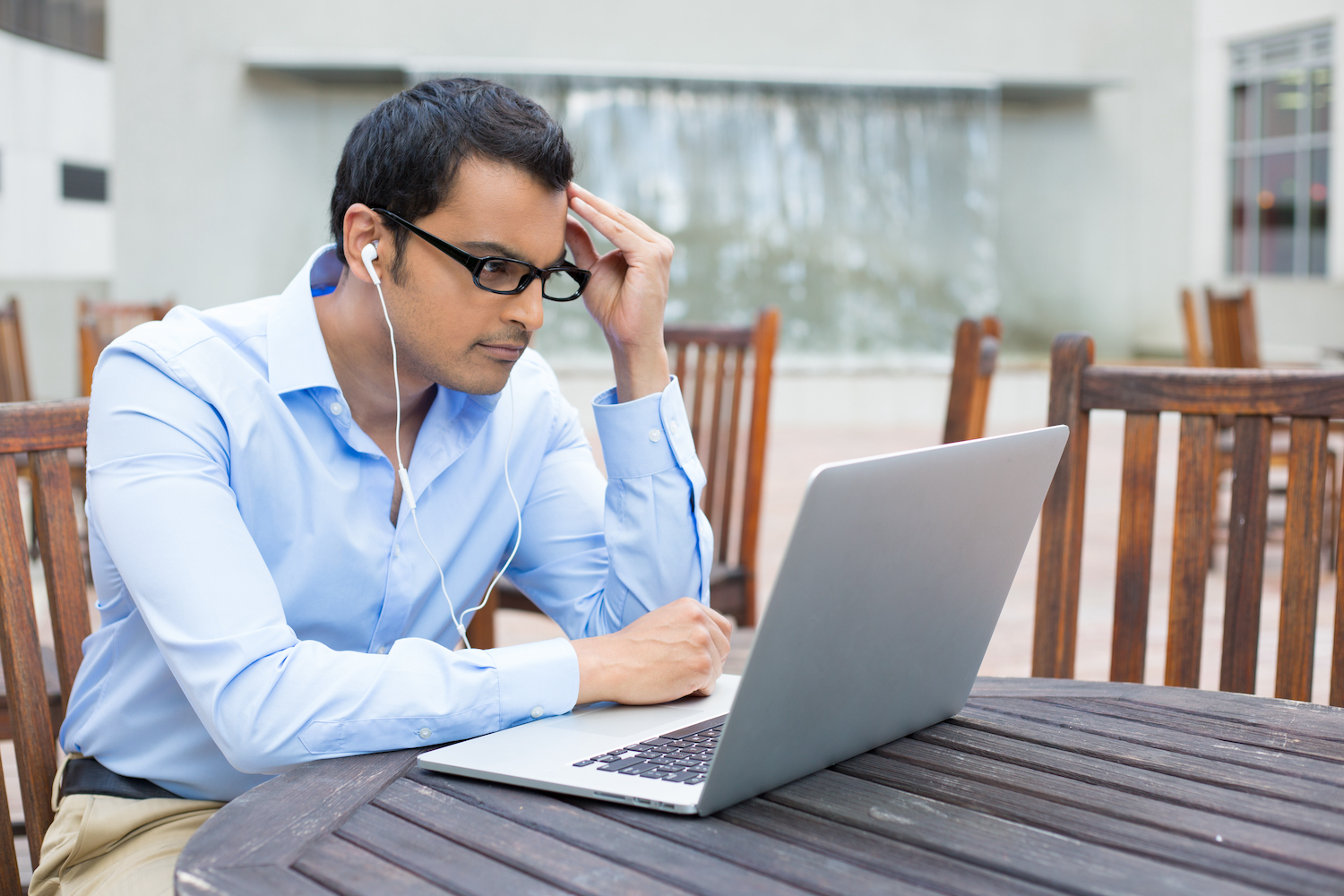 A young insurance agent searching on a laptop for answers to which risk assessment certification is best