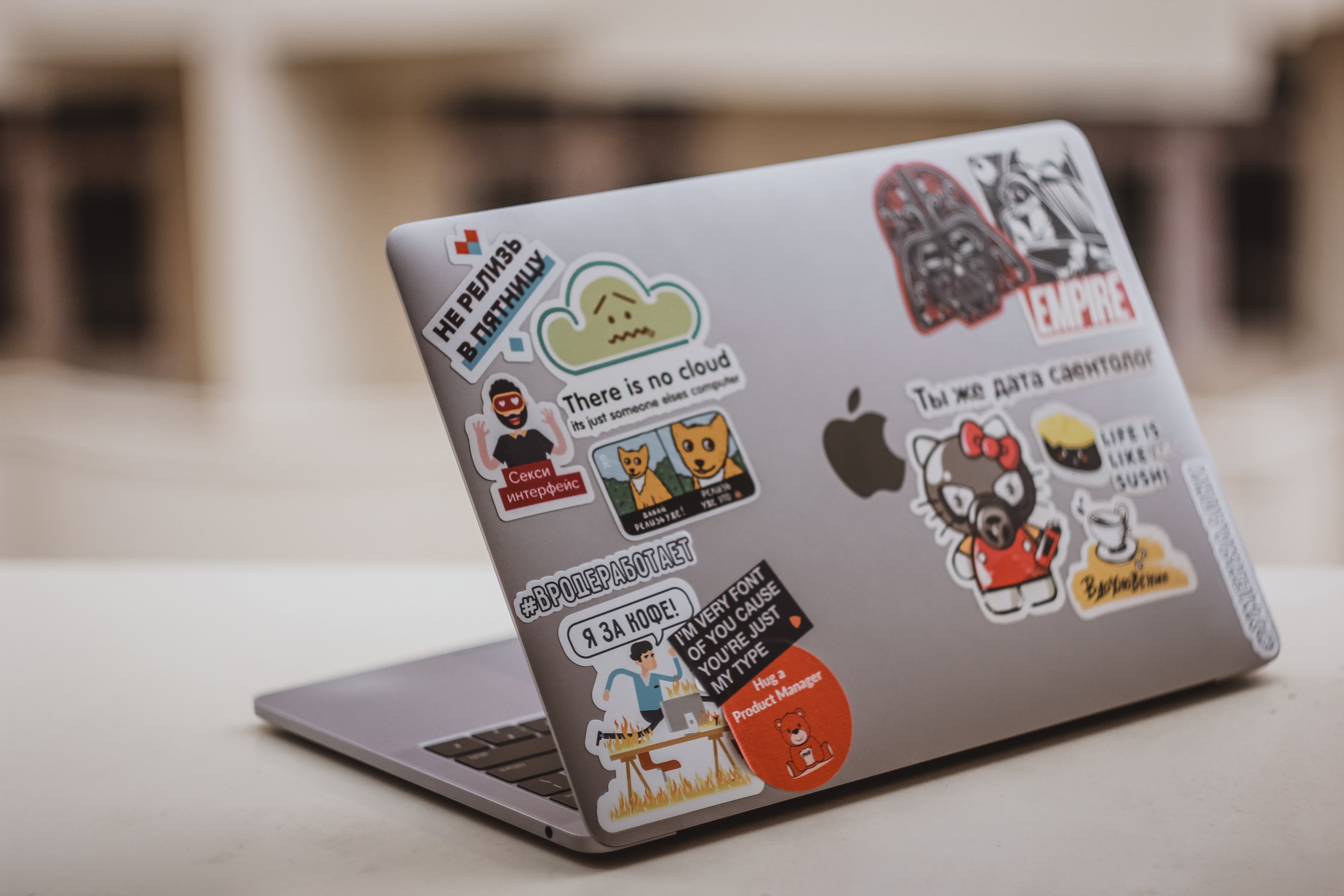 a laptop with several miscellaneous stic0kers on the back