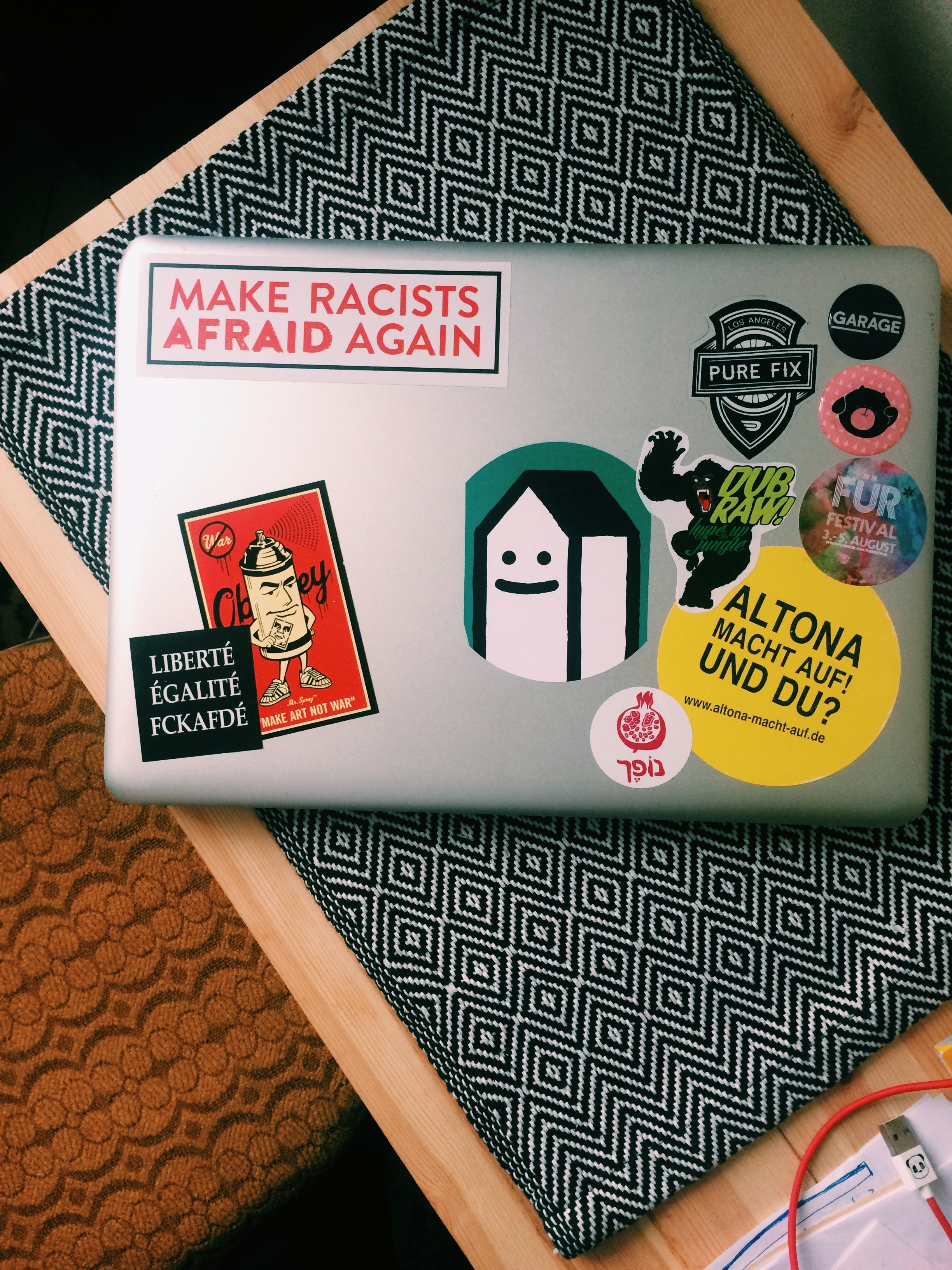 the back of a closed laptop with a couple of miscellaneous stickers